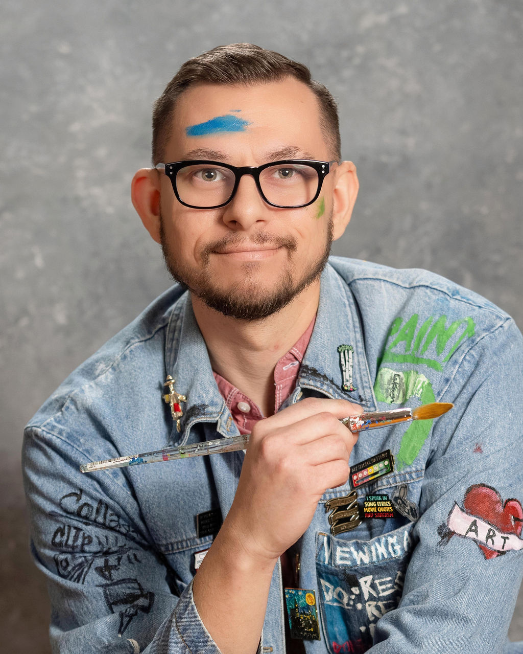 Portrait of artist and educator James Carey holding a paintbrush